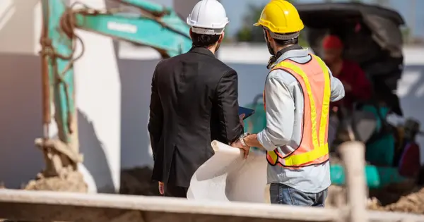 Operário e engenheiro conversando em um canteiro de obras